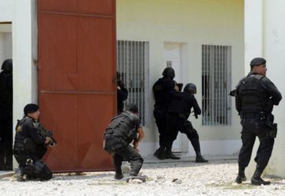 Police surround a house on Monday during an operation in Santa Elena, Guatemala.