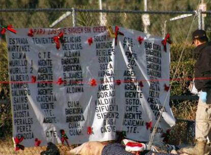 Un policía observa, junto a una lista de amenazados, los cuatro cadáveres hallados a pocos metros de la Comandancia de Policía Estatal (Cipol) en Ciudad Juaréz.