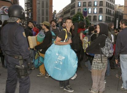 Agentes de Policía custodian en Callao a uno de los grupos de las que estaban acampadas en la madrileña Puerta del Sol.