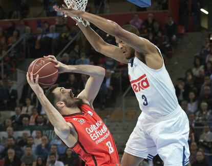 El ala pivot del Valencia Basket, Pierre Oriola (i), intenta encestar ante la defensa del pivot estadounidense del Real Madrid, Anthony Randolph.