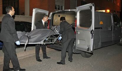 Operarios del servicio funerario retira el cuerpo de la mujer asesinada.