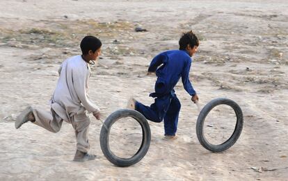 Niños afganos juegan con neumáticos en las afueras de Herat (Afganistán), 27 de octubre de 2013.