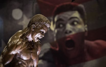 Una estatua de Muhammad Ali frente a una imagen del púgil que forman parte de la exposición.