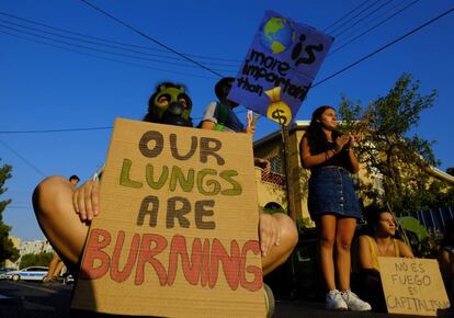 "Nossos pulmões estão queimando", afirma faixa de grupo de manifestantes em frente a embaixada do Brasil em Nicósia, Chipre.