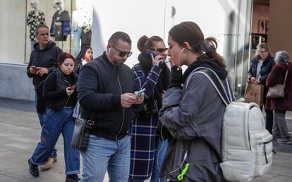 Usuarios de telefonía móvil en la Gran Vía de Madrid.