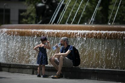 Vecinos refrescándose ante una fuente en el tercer día de la ola de calor, en Barcelona, esta semana.