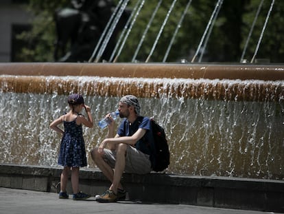 Vecinos refrescándose ante una fuente en el tercer día de la ola de calor, en Barcelona, esta semana.