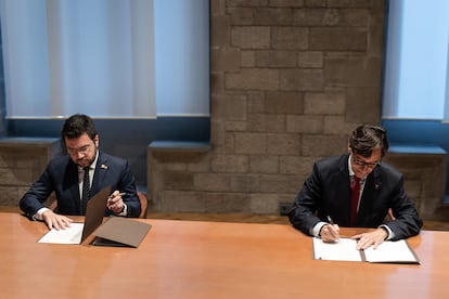 Pere Aragonès (izquierda) y Salvador Illa firman el acuerdo, este miércoles en el Palau de la Generalitat.