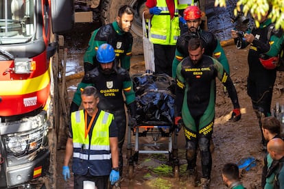 Agentes de la Guardia Civil sacan un cadáver del aparcamiento en Benetússer, el 2 de noviembre de 2024.