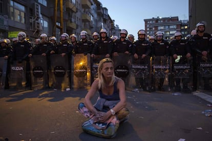 Una mujer permanece sentada frente a un cordón policial tras un enfrentamiento durante una manifestación contra el presidente serbio Aleksandar Vucic frente al edificio presidencial en Belgrado. Partidarios de la oposición se reunieron frente al edificio presidencial durante una conferencia de prensa del presidente serbio Aleksandar Vucic, un día después de que los opositores irrumpieran en el edificio estatal de televisión RTS, exigiendo dirigirse a la población, en imágenes transmitidas en vivo.