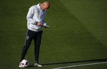 Zinedine Zidane revisa su libreta durante un entrenamiento.
