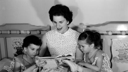 Delia Gondar reads a book to her children Delia María and Conchita before bedtime, in her home in Marianao, Cuba, around 1955.