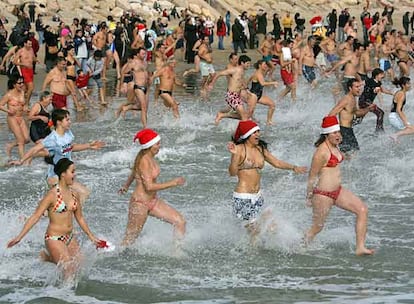 Decenas de bañistas se meten en el agua en la playa del Miracle de Tarragona.