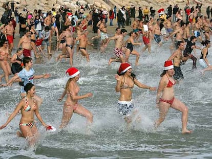 Decenas de bañistas se meten en el agua en la playa del Miracle de Tarragona.