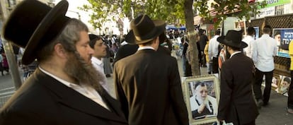 Jud&iacute;os ultraortodoxos caminan junto a un retrato del difunto l&iacute;der espiritual sefard&iacute;, Ovadia Yosef, el pasado octubre en Jerusal&eacute;n.