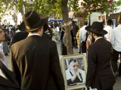 Judeus ultraortodoxos caminham ao lado de um retrato do líder espiritual já morto, o sefardita Ovadia Yosef, em outubro em Jerusalém.