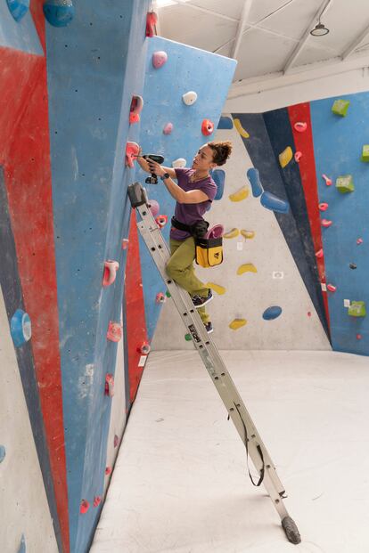 Shirleys Noriega, realiza su trabajo de route setter atornillando una presa en el rocódromo The Climb, en Madrid.