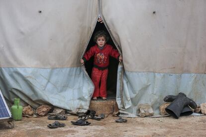 El 19 de enero de 2021, un niño mira desde una tienda de campaña en el campamento de Kafr Losin, en el noroeste de Siria. En los días anteriores, Alepo e Idlib, en el noroeste del país, han experimentado algunas de las tormentas invernales más intensas en este invierno. Las fuertes lluvias han inundado las tiendas de campaña y cortado las carreteras que conducen a los campamentos para familias desplazadas internamente. Si bien se siguen evaluando los daños, hay informes de que más de 1.700 hogares de la zona se han visto afectados por las inundaciones, exponiendo a los niños al empeoramiento de las severas condiciones invernales. Unicef estima que 1,2 millones de niños en el noroeste de Siria tienen necesidades urgentes insatisfechas. Los niños y las familias se refugian en instalaciones públicas, escuelas, mezquitas, edificios sin terminar y tiendas. Muchos viven al aire libre, incluso en parques, en medio de fuertes lluvias y un frío glacial. El acceso a los servicios más básicos como salud, agua o saneamiento es muy limitado o inexistente.  La reciente recesión económica en Siria y el impacto de la epidemia de coronavirus han agravado aún más una situación desesperada.