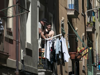 Varias personas pasan en confinamiento en los balcones de un bloque de pisos de la Barceloneta.