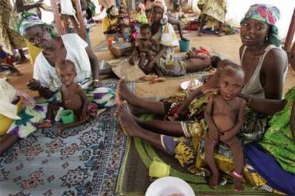 Niños de Níger con sus madres reciben alimentos en un centro especializado en nutrición de Maradi.