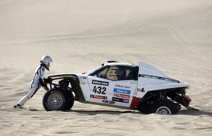 El copiloto argentino Mauro Esteban trata de levantar el coche de su piloto italiano Gianpaolo Bedin