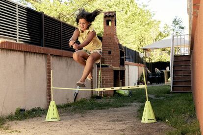 Andrea Marqués Antón juega en el jardín a saltos de caballo.