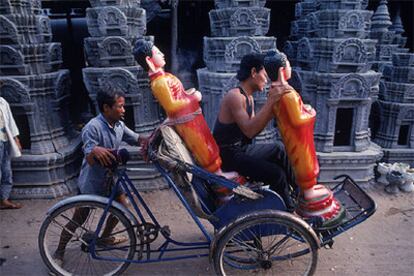 Un carrito transporta estatuas de Buda en la zona monumental de Phnom Penh.