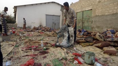 Un hombre sostiene prendas quemadas tras el atentado en Jaar (Yemen).