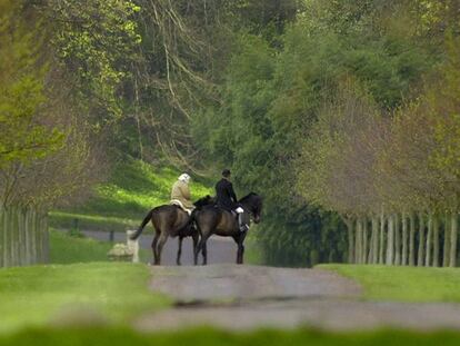 La reina Isabel en los jardines de Windsor, con un acompañante.