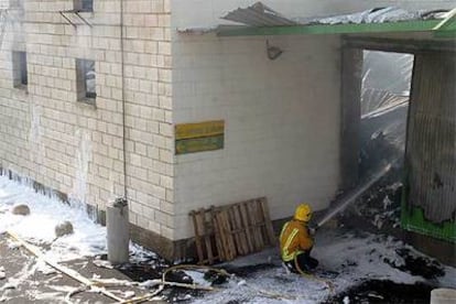 Un bombero dirige su manguera hacia el fuego en el almacén del hospital de La Villa Joiosa, ayer.