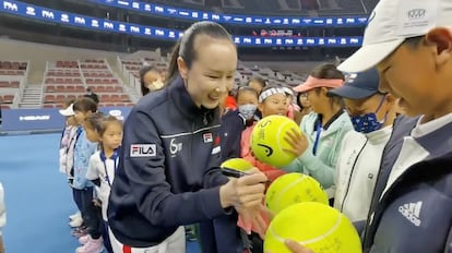 La tenista china Peng Shuai firma unas pelotas de tenis en un torneo juvenil en el que reapareció en Pekín el 21 de noviembre.