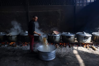 Un hombre palestino prepara comida para un campamento de la ONU donde será distrubuida entre los desplazados de Rafath.