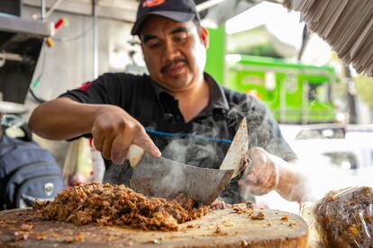 Un taquero prepara tacos de birria.