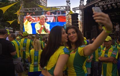 Duas garotas fazem uma selfie enquanto assistem o jogo entre Brasil e Suíça em um telão instalado em um bairro do Rio de Janeiro, no dia 17 de junho de 2018.