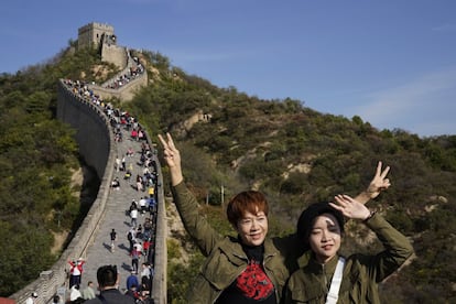 Dos turistas posan para una foto en un tramo de la Gran Muralla China de Badaling en las afueras de Pekín. Los turistas chinos realizaron 425 millones de viajes internos en la primera mitad de las fiestas de ocho días del Día Nacional, generando 45,9 mil millones de dólares en ingresos por turismo, según el Ministerio de Cultura y Turismo de China. Las vacaciones de este año, que coincide con el Festival de Medio Otoño, serán una prueba de fuego para ver si la industria turística de China puede recuperarse después de haber sido golpeada por la pandemia de la covid-19.