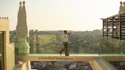 Un camarero cruza la pasarela de la terraza del hotel Riu Plaza de España, en Madrid.