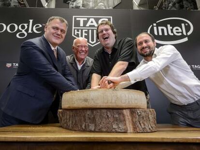 Guy Semon, director general de Tag Heuer; Jean-Claude Biver, consejero delegado de la misma empresa; Michael Bell, ejecutivo de Intel; y David Singleton, director de ingeniería de Android en Google, posan con un queso suizo tras el anuncio de su asociación para el desarrollo de relojes inteligentes