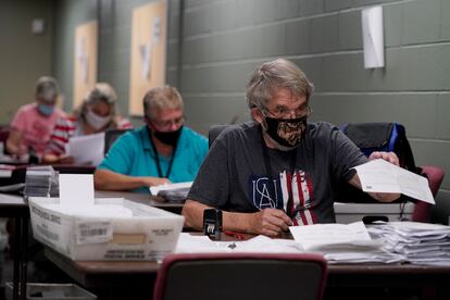 Varios trabajadores clasifican las peticiones del voto por correo, en una oficina en Olathe, Kansas.