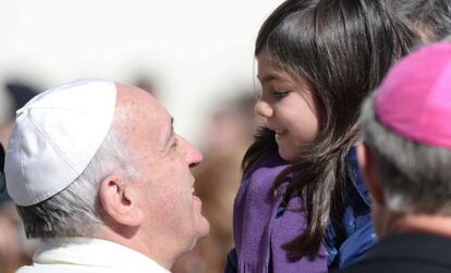 El Papa Francisco charla con una niña durante la audiencia general de los miércoles en la Plaza de San Pedro.