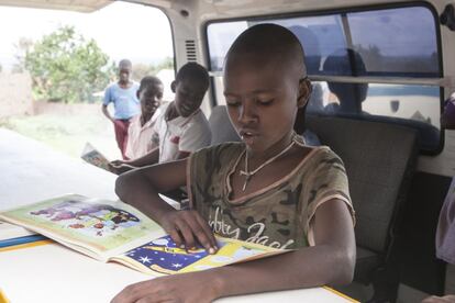 Un niño de la calle lee un libro en la furgoneta de Matatart. Uno de los objetivos de la organización es ayudar a que los pequeños conozcan el arte y aprendan a leer, escribir y pintar.