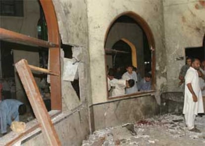 Miembros de los equipos de rescate inspeccionan la mezquita de Karachi donde estalló la bomba.