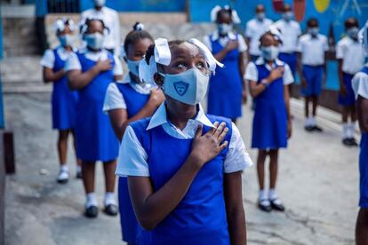 Un grupo de estudiantes participan en una ceremonia antes de retomar las clases cinco meses después del cierre de los colegios por la pandemia de coronavirus, en Puerto Príncipe (Haití).