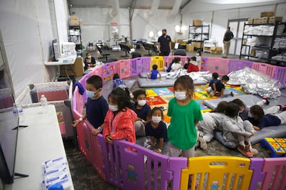 Niños migrantes no acompañados miran televisión en un centro de detención para menores en Donna, Texas, en 2021.