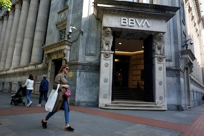 Una mujer pasea por delante de una oficina del BBVA.