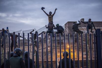 Un grupo de inmigrantes subsaharianos resiste en lo alto de la valla que separa Marruecos del enclave español de Melilla el 28 de marzo de 2014. Las autoridades dijeron que unos 300 personas, en su mayoría subsaharianas, trataron de escalar la valla por la parte noroeste de la ciudad.