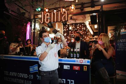 Un sanitario prepara una inyección ante un bar donde se ofrece una bebida gratis a quienes se vacunen contra la covid, el jueves en Tel Aviv.