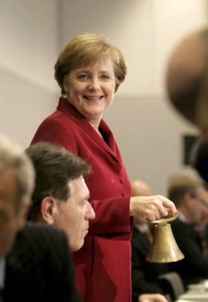 Merkel toca una campana en la reunión de la CDU ayer en Berlín.