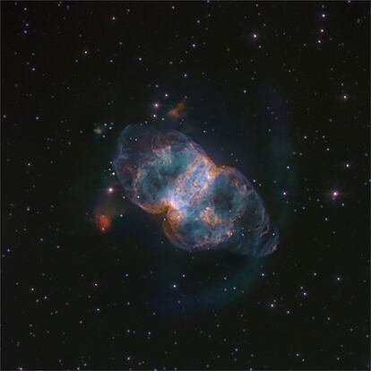 La nebulosa planetaria M76 se conoce también como <i>Little Dumbbell</i> (pequeña pesa o mancuerna) por su parecido con la nebulosa Dumbbell. M76 fue descubierta en 1780 por Pierre Méchain, aunque no fue hasta 1918 cuando Heber D. Cirtis la clasificó como nebulosa planetaria. La pequeña Dumbbell está en la constelación de Perseo, a unos 8.000 años luz de la Tierra, y su halo se extiende alrededor de 20 años luz. Su anillo central se expande a una velocidad de 42 km/seg. En esta imagen pueden distinguirse estructuras difícilmente apreciables en otras fotos publicadas de este objeto. Hay tres <i>chorros</i> de color rojizo que surgen en la parte superior, uno pequeño hacia arriba y dos mayores hacia los laterales. Asimismo, puede observarse un halo semicircular azulado que envuelve al objeto en la parte inferior. La foto fue tomada con el Telescopio IAC80, en el Observatorio del Teide, propiedad del Instituto de Astrofísica de Canarias. Texto: Álex Oscoz Abad y Pablo Rodríguez Gil.