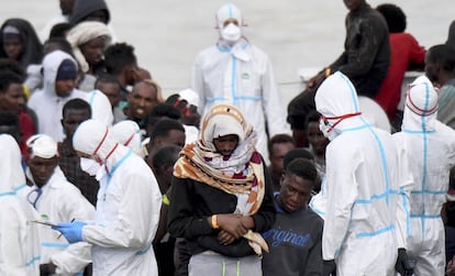 Un grupo de migrantes espera, este viernes, para desembarcar en el puerto de Catania (Italia).