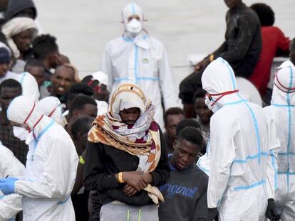 Un grupo de migrantes espera, este viernes, para desembarcar en el puerto de Catania (Italia).
